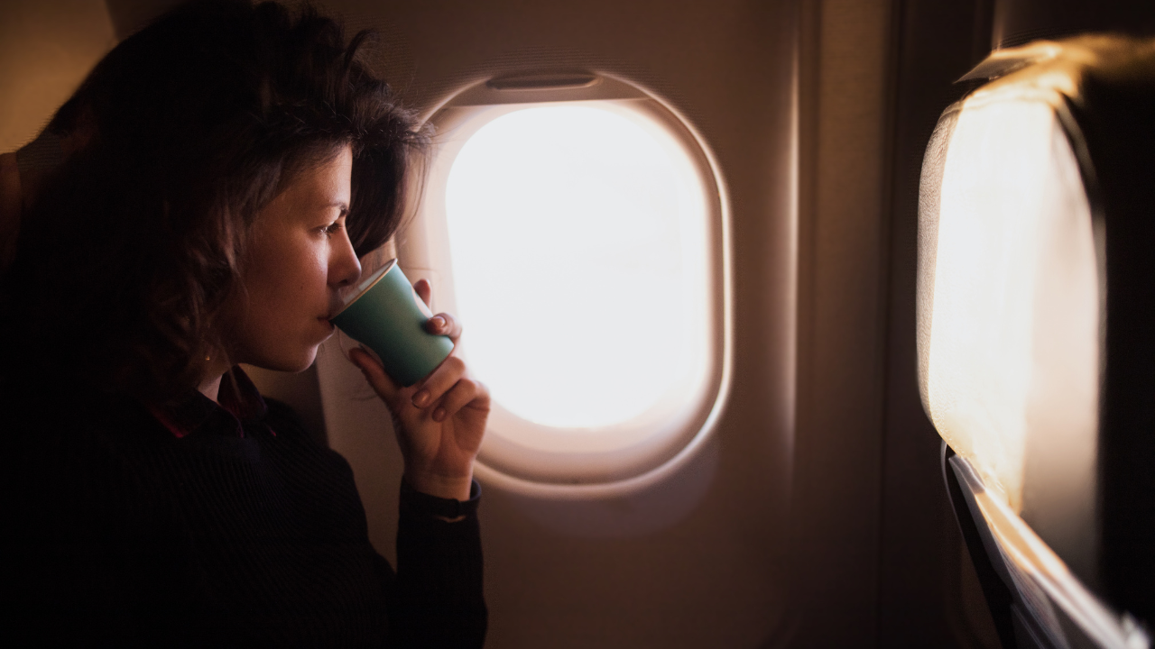 機内でコーヒーを飲む女性
